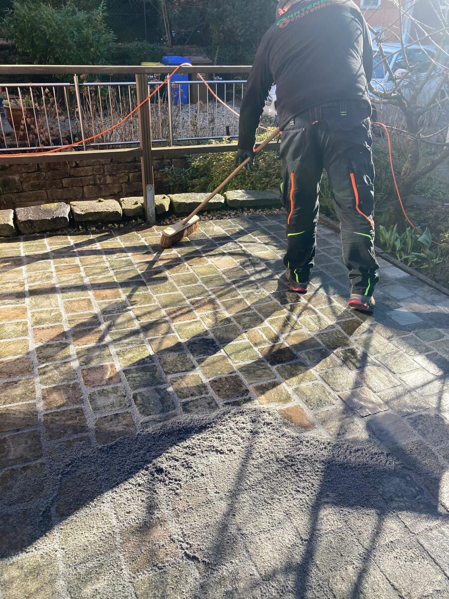 Mitarbeiter beim Verfugen der Pflasterfläche
