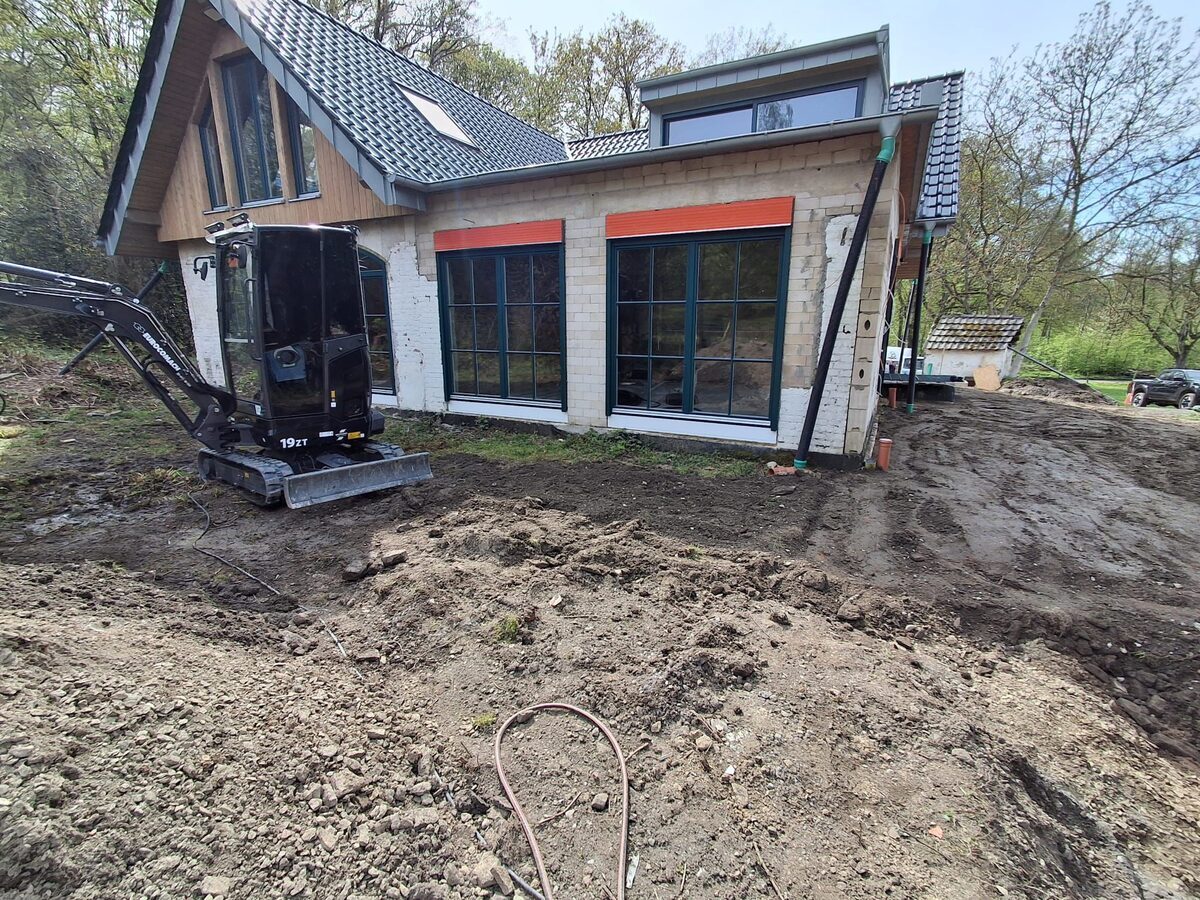 Minibagger bei Erdarbeiten vor Neubau
